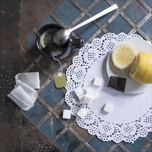 Cup of tea with lemon and sugar on lace doily