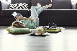 Caucasian woman using digital tablet on floor