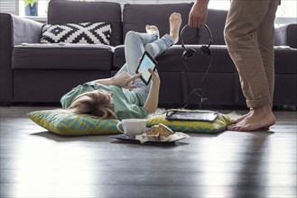 Caucasian couple using digital tablets on floor
