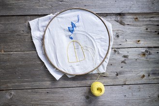 Ball of yellow thread with needlepoint hoop