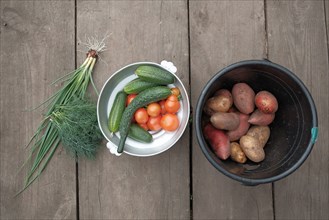 Fresh vegetables and potatoes on wooden table