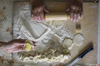 Hands of Caucasian woman rolling pastry dough