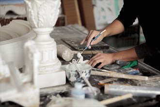 Caucasian artist sculpting with tool