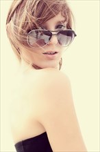 Portrait of Caucasian teenage girl wearing sunglasses in wind