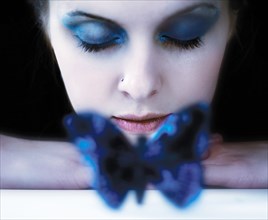 Caucasian teenage girl resting near blue butterfly