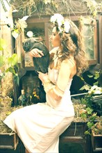 Caucasian woman sitting in garden holding rabbit