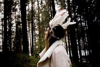 Caucasian woman wearing headdress in forest