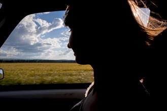 Silhouette of smiling woman passenger in car