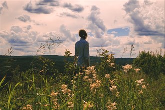 Woman standing in field of wildflowers