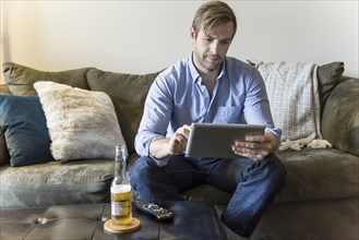 Man using digital tablet on sofa