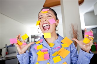 Hispanic businesswoman covered in sticky notes