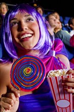 Woman eating candy and popcorn in movie theater