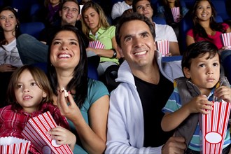 Hispanic family enjoying popcorn at movie theater
