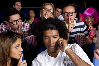 People quieting noisy person in movie theater