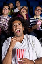 Hispanic people enjoying popcorn in movie theater