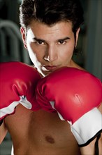 Hispanic man wearing boxing gloves