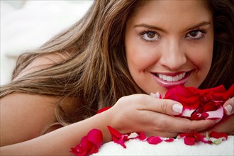 Hispanic woman smelling rose petals