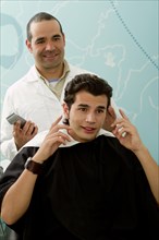 Hispanic Barber listening to client in barber shop
