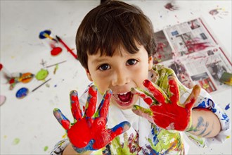 Messy Hispanic boy finger painting