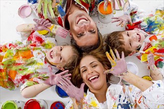 Hispanic family covered in paint laying on floor