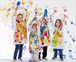 Messy Hispanic children covered in paint