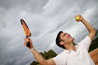 Hispanic man cheering on tennis court