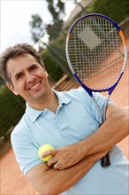 Hispanic man standing on tennis court with racquet