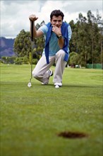 Hispanic man assessing golf course