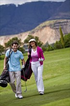 Hispanic couple playing golf together