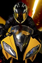 Hispanic biker in reflective helmet riding motorcycle