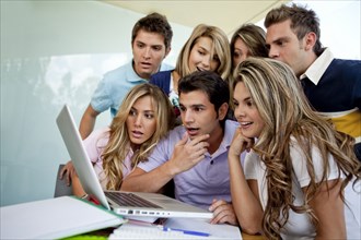 Hispanic college students looking at laptop together