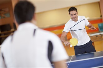 Hispanic men playing ping pong