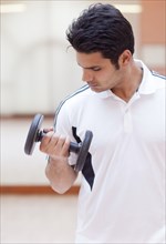 Hispanic man lifting weights in gym