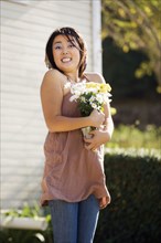 Excited Chinese woman holding bouquet of flowers