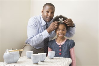African father and daughter posing with tiara