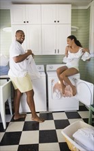 Playful couple folding laundry