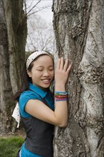Chinese girl hugging tree