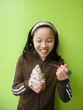 Chinese girl eating ice cream with sprinkles