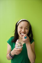 Chinese girl eating ice cream with sprinkles