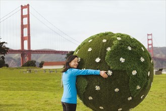 Chinese girl hugging earth topiary