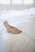 Woman's feet on end of bed