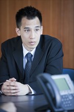 Chinese businessman sitting in conference room
