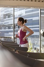 Woman running on treadmill in health club