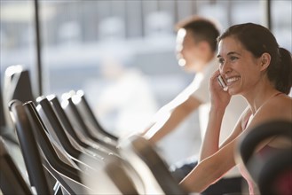 Woman using cell phone on treadmill