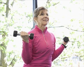 Woman lifting weights in health club