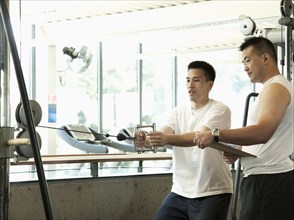 Man working with personal trainer in health club