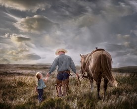 Caucasian father and daughter walking horse in field