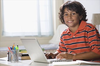 Mixed Race boy typing on laptop