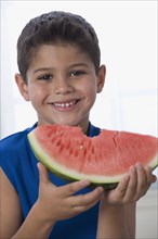 Hispanic boy eating watermelon