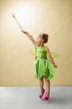 Girl wearing green fairy costume with wand